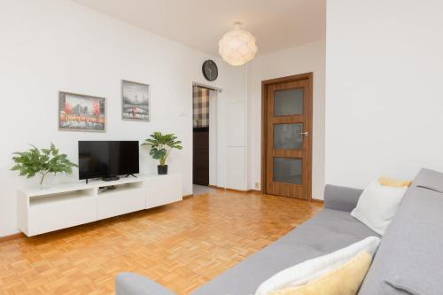 a living room with a couch and a tv at Warsaw Magellana Apartment by Renters in Warsaw