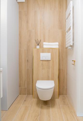 a bathroom with a white toilet in a room at POLANKI AQUA Apartamenty PREMIUM - w cenie nielimitowany dostęp do strefy Aqua in Kołobrzeg