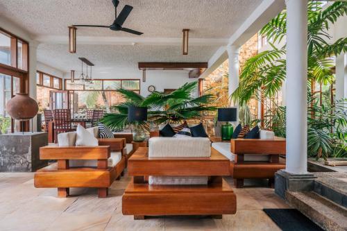 a living room with wooden furniture and plants at Sānti Beach House with pool & beach in Weligama