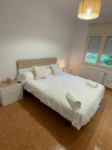 a bedroom with a large bed with two towels on it at Casa Veuràs Girona - Montilivi in Girona