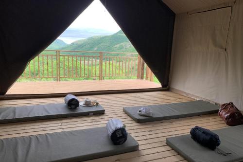 a room with two beds and a large window at Matatane Camp - Babanango Game Reserve in Nkwalini