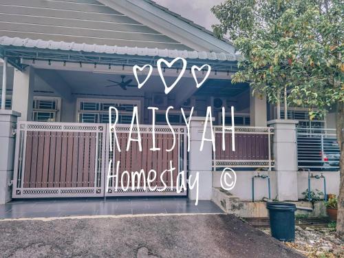 ein Haus mit einem Tor mit einem Schild, das Hallo liest in der Unterkunft Raisyah Homestay, Melaka in Malakka