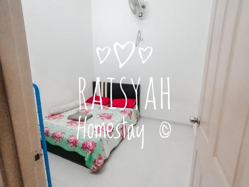 ein Schlafzimmer mit einem Bett mit heimischem Schild in der Unterkunft Raisyah Homestay, Melaka in Malakka