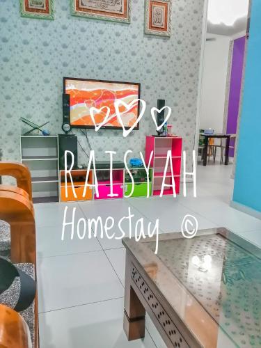 ein Wohnzimmer mit einem Schild, das Rosinen-Heim-Inszenierung liest in der Unterkunft Raisyah Homestay, Melaka in Malakka