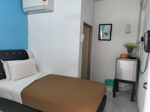 khairul homestay taman tengiri seberang jaya في Kampong Telok: غرفة نوم صغيرة بها سرير وتلفزيون