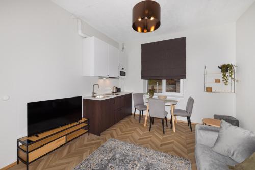 a living room with a kitchen and a table with chairs at Peetri Apartments in Tartu