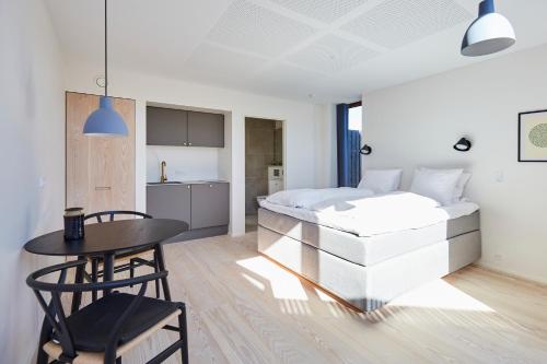 a bedroom with a bed and a table and chairs at Vesterlandet in Vestervig