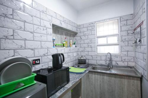 eine Küche mit einer Spüle und einer Mikrowelle in der Unterkunft Amazing Grace Hostel and International Serviced Apartments in Ibadan