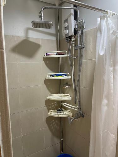 a shower with three shelves in a bathroom at relaxing city view in Manila