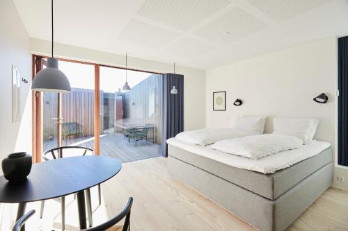 1 dormitorio con cama, mesa y comedor en Vesterlandet, en Vestervig
