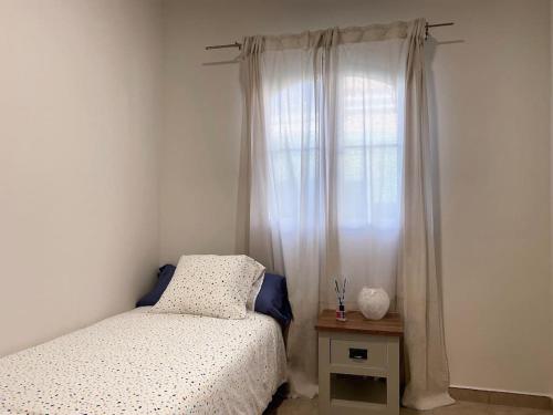 a small bedroom with a bed and a window at Comfortable family house with pool and jacuzzi in Costa de Antigua