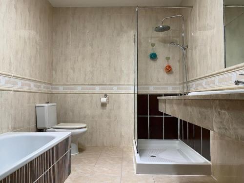 y baño con bañera, aseo y ducha. en Comfortable family house with pool and jacuzzi, en Costa de Antigua