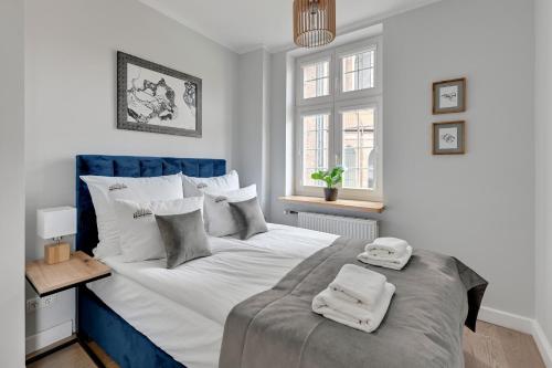 a bedroom with a large bed with two towels on it at Downtown Apartments Old Town Mariacka in Gdańsk