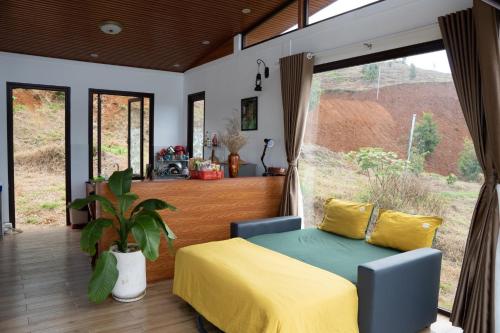 a bedroom with a bed and a large window at Thỏ Non Garden Villa Bảo Lộc in Bao Loc
