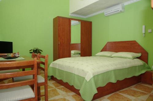 1 dormitorio con cama, mesa y escritorio en Nefelejcs Apartman, en Gyula