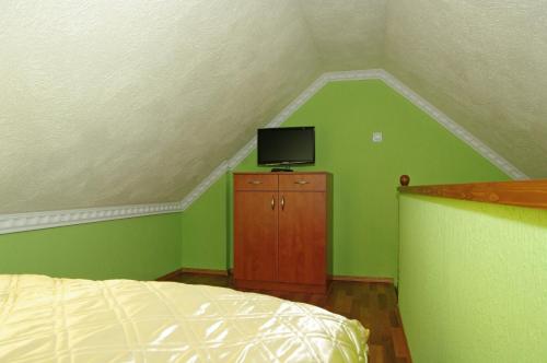 a bedroom with a bed and a tv on a dresser at Nefelejcs Apartman in Gyula