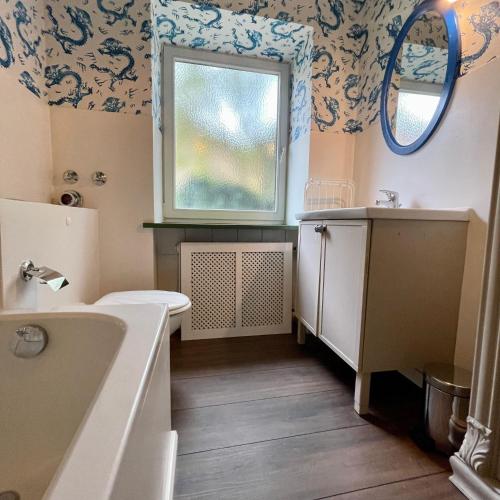 a bathroom with a sink and a toilet and a window at Ferienwohnung "Tegernsee-II" in Tegernsee