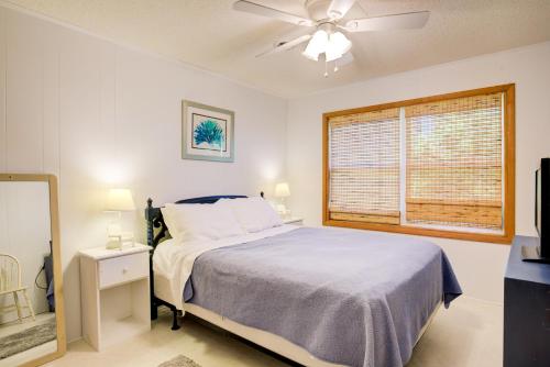 um quarto com uma cama, uma ventoinha de tecto e uma janela em Blue Crab em Surf City