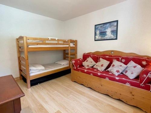 - une chambre avec 2 lits superposés et un canapé rouge dans l'établissement Spacieux 4 pièces avec parking et vue imprenable à Praz-sur-Arly - FR-1-603-40, à Praz-sur-Arly