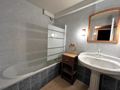 une salle de bain avec un lavabo et une baignoire dans l'établissement Belmont 26 - Appartement duplex centre, à La Clusaz