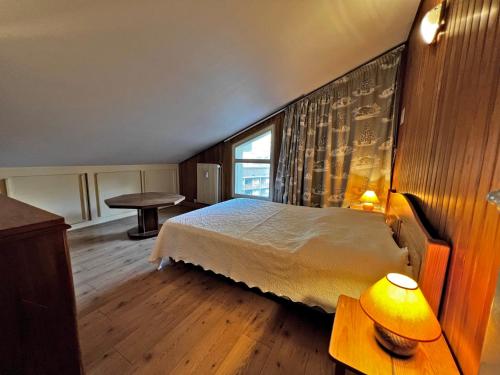 une chambre avec un lit et une table avec une lampe dans l'établissement Belmont 26 - Appartement duplex centre, à La Clusaz