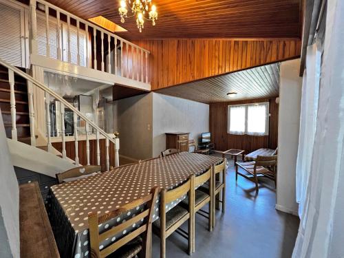 une salle à manger avec une table et des chaises et des escaliers dans l'établissement Belmont 26 - Appartement duplex centre, à La Clusaz