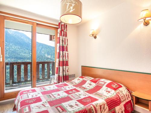 a bedroom with a bed and a large window at Vacancéole - Le Dôme des Rousses in Vaujany