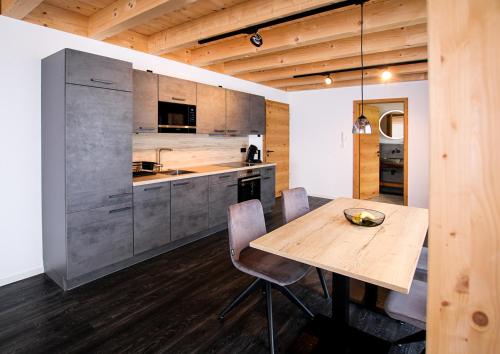 a kitchen with a wooden table and chairs at Mountain Moments Tannheim - Familie Weber in Tannheim