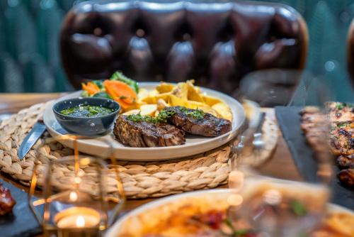 a plate of food with meat and chips on a table at Sky Roof Hotel in North Nicosia