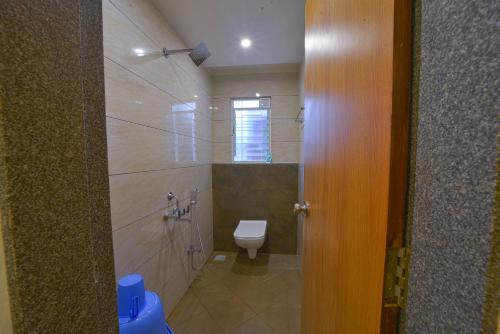 y baño con aseo y ducha. en Hotel TrushaDham Near to Mahalaxmi Temple Kolhapur, en Kolhapur