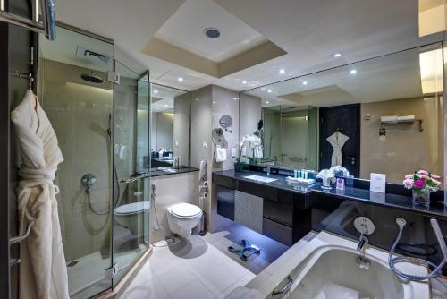 Mercure Gold Hotel, Jumeirah, Dubai في دبي: حمام مع دش ومرحاض ومغسلة