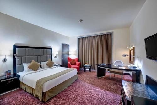 Mercure Gold Hotel, Jumeirah, Dubai في دبي: غرفة الفندق بسرير كبير ومكتب