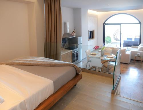 a bedroom with a bed and a kitchen and a dining room at Zeus Throne Suites in Afionas