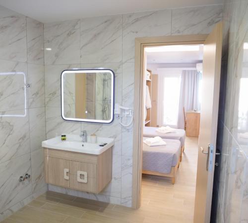 a bathroom with a sink and a mirror at Zeus Throne Suites in Afionas