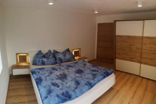 a bedroom with a bed with blue sheets and pillows at Apart MountainView in Bruck am Ziller