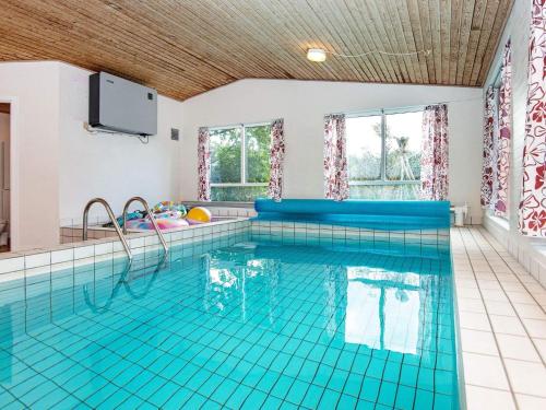 a large swimming pool with blue tiles on the floor at 10 person holiday home in Glesborg in Fjellerup Strand