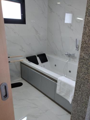 a bathroom with a bath tub with a window at Vonando in Geres