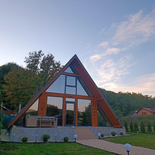 a frame house with a picnic table in a yard at Cabana A-frame Nis in Coţofăneşti
