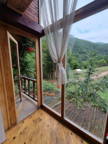 a room with a view of a porch with a window at Grab cabin in Pluzine