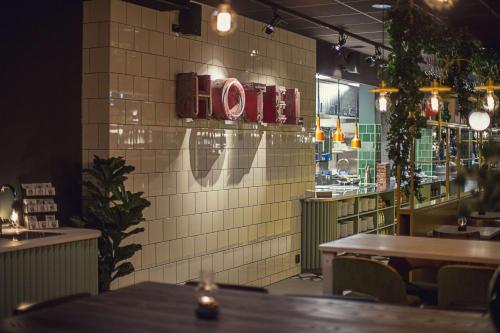 a restaurant with tables and a sign on a wall at Best Western Plus Hus 57 in Ängelholm