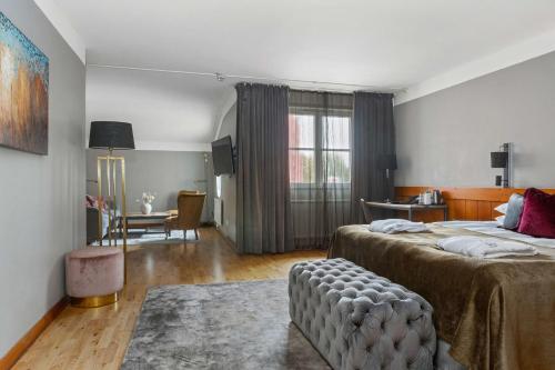 Habitación de hotel con 2 camas y sala de estar. en Best Western Gustaf Wasa Hotel en Borlänge