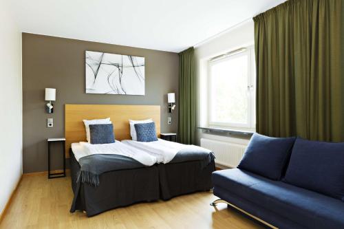 a bedroom with a bed and a couch at Hotel Allén - Sure Hotel by Best Western Allen in Gothenburg