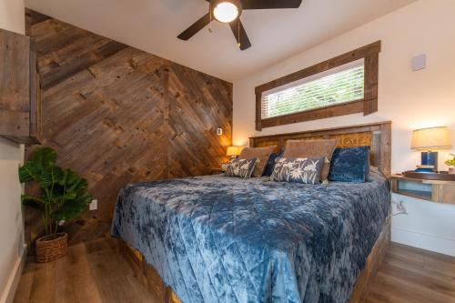 Un dormitorio con una cama con una pared de madera. en Mockingbird Treehouse 15 MIN to MagnoliaBaylor, en Elm Mott
