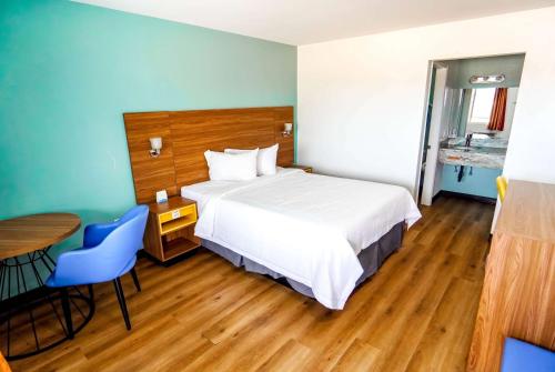 une chambre d'hôtel avec un lit, une table et des chaises dans l'établissement Days Inn by Wyndham Victorville, à Victorville
