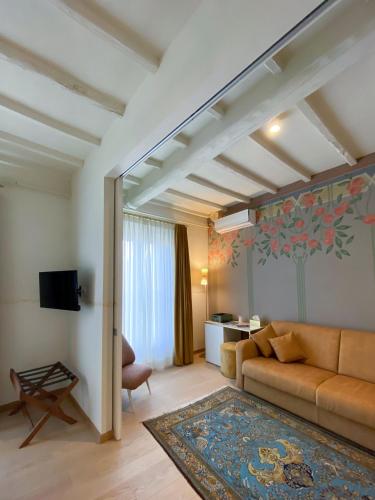 un soggiorno con divano e un tavolo di PALAZZO ESSENZA a San Miniato