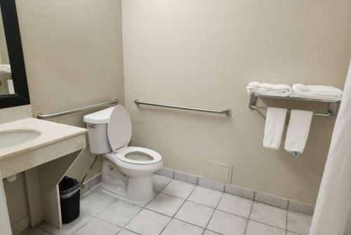 uma casa de banho com WC e um lavatório com toalhas em Baymont by Wyndham Houston Brookhollow em Houston