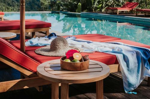 un bol de fruta en una mesa junto a una piscina en Buahan, a Banyan Tree Escape en Payangan