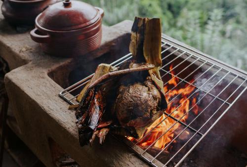 a piece of meat being grilled on a grill at Buahan, a Banyan Tree Escape in Payangan