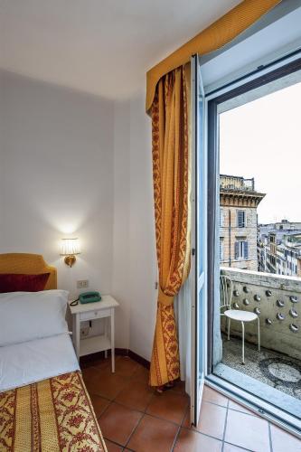 sypialnia z łóżkiem i dużym oknem w obiekcie Hotel Canova w Rzymie
