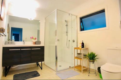 y baño con ducha, lavabo y aseo. en skyline mountain view Lodge up to 16 people en Rotorua